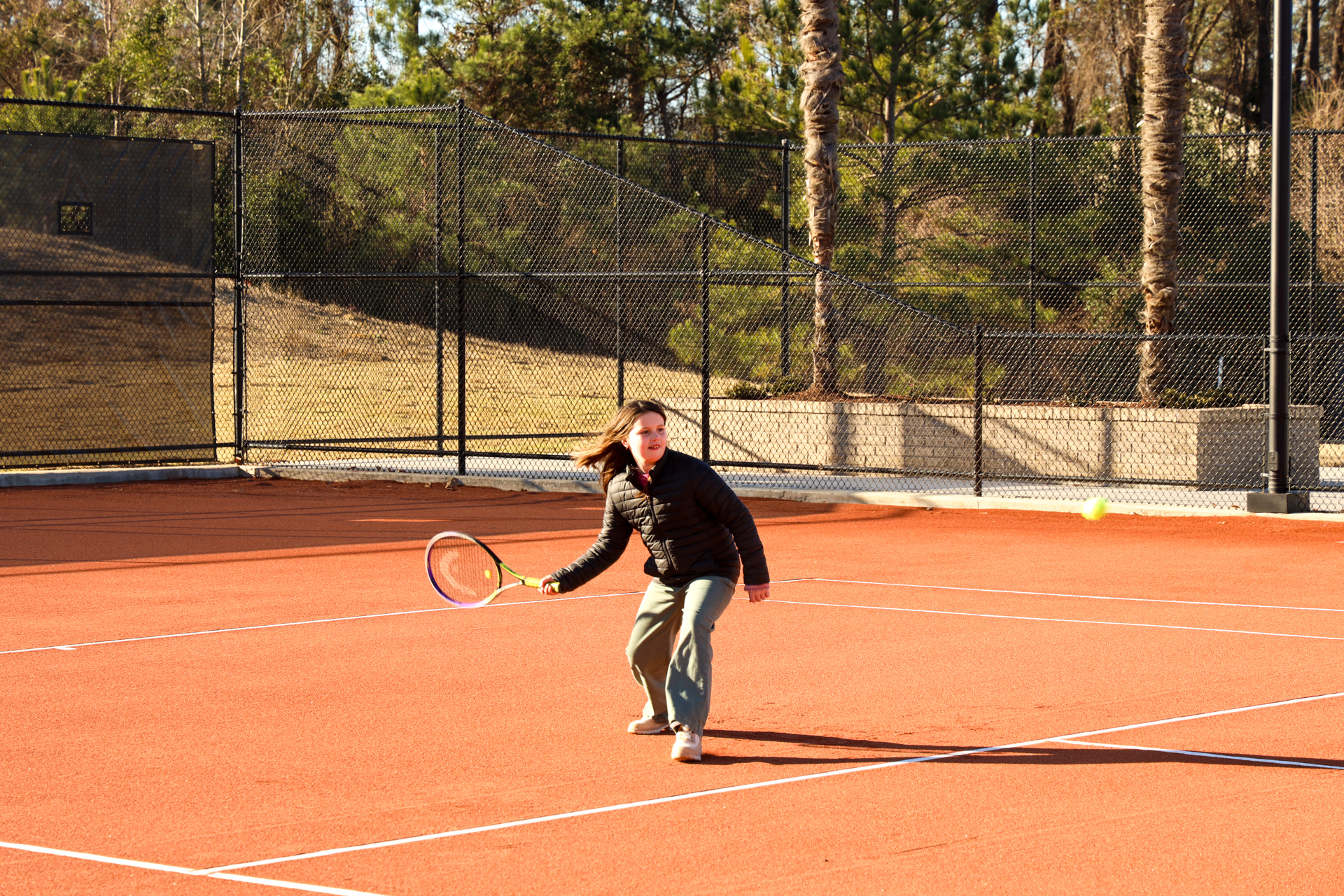 Girl plays tennis on new red clay courts at the Palmetto Tennis Center