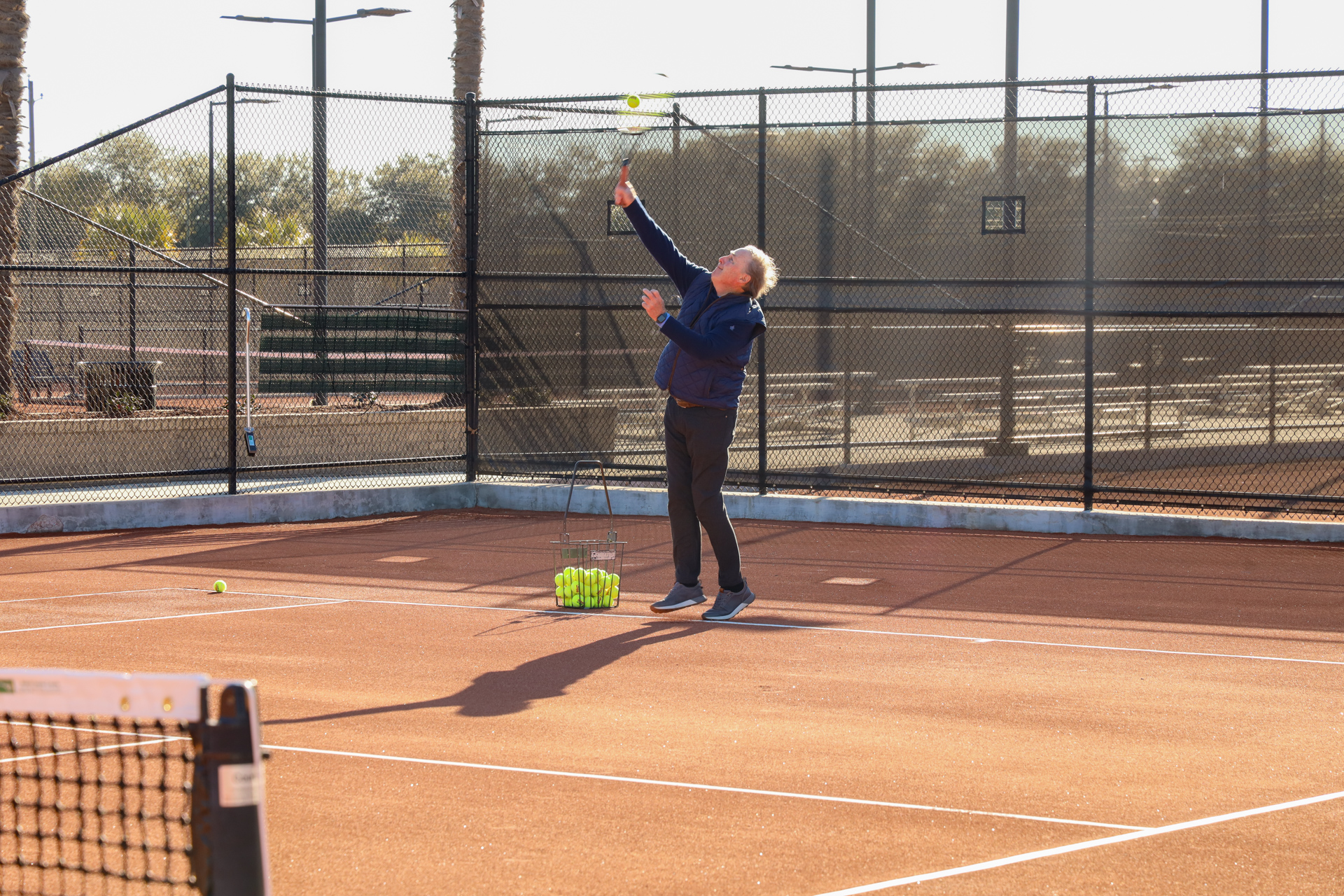 Councilman Shaw serves on the red clay courts at Palmetto Tennis Center